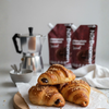 Croissants on a wooden board with a coffee maker and Chocolate Hazelnut Nut Dreamers
